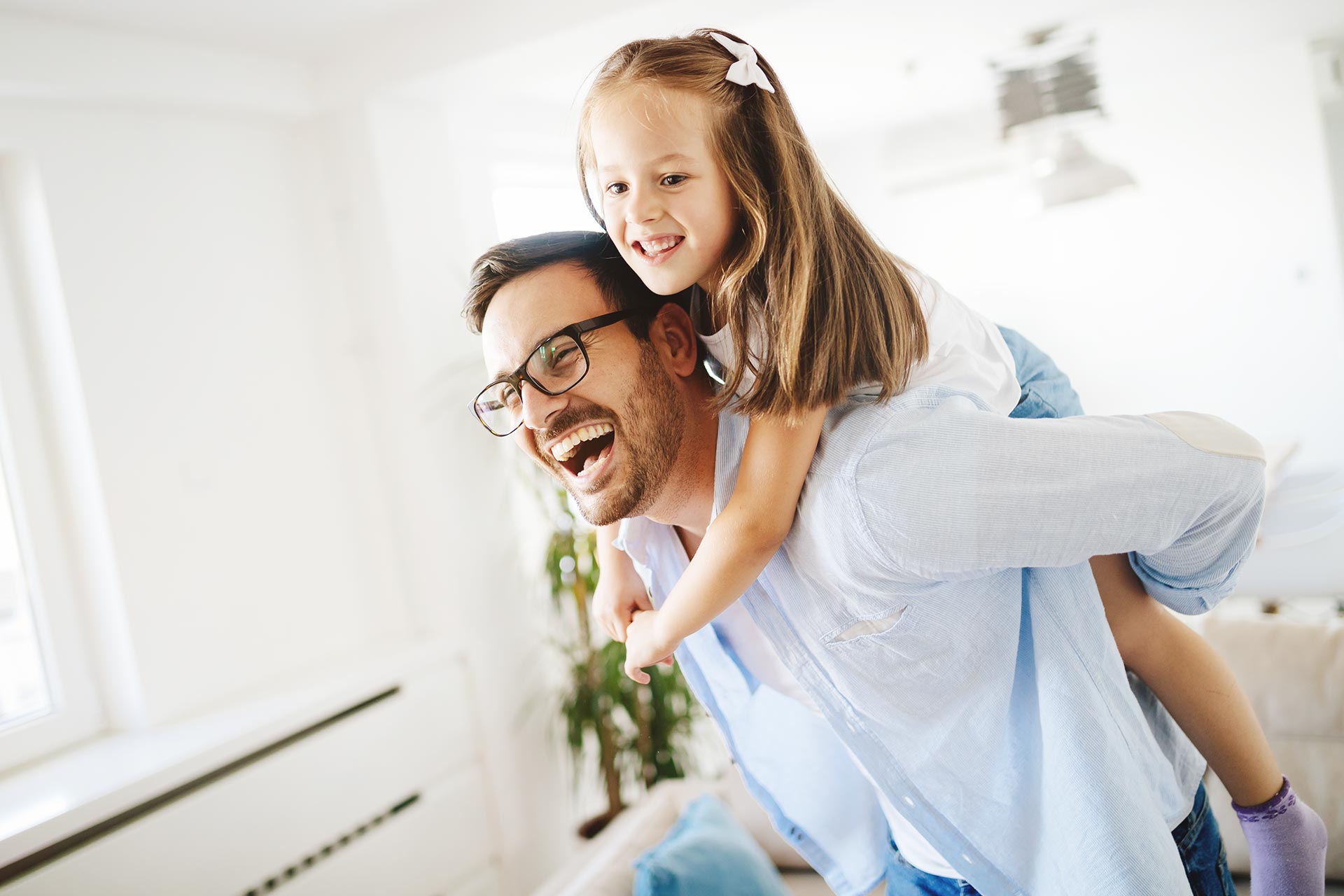 portrait of father and daughter playing at home R7SPLMX