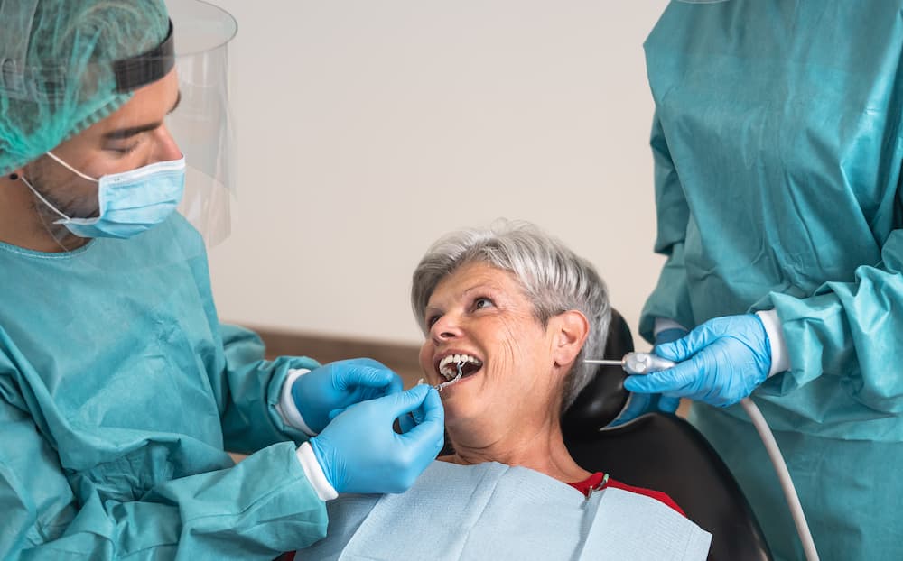 man-dentist-operating-senior-woman-in-dental-clini-6YPFYRW (1)