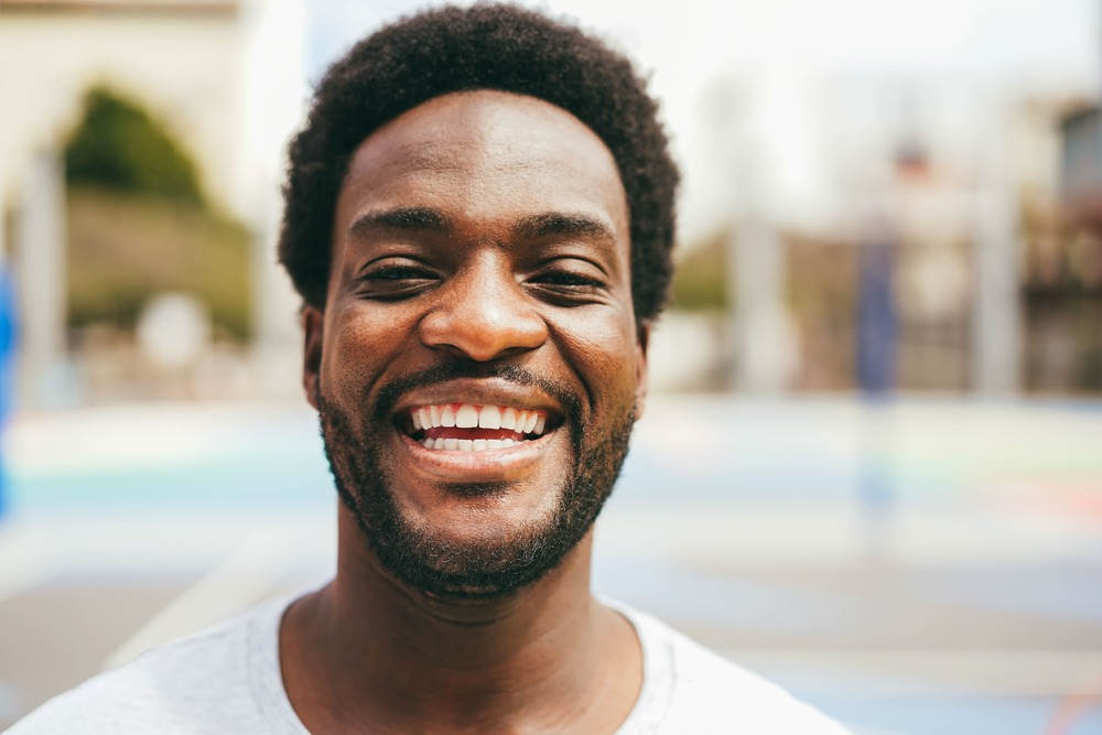 happy african man smiling at camera inside basketb 2022 04 29 00 30 00 utc 1